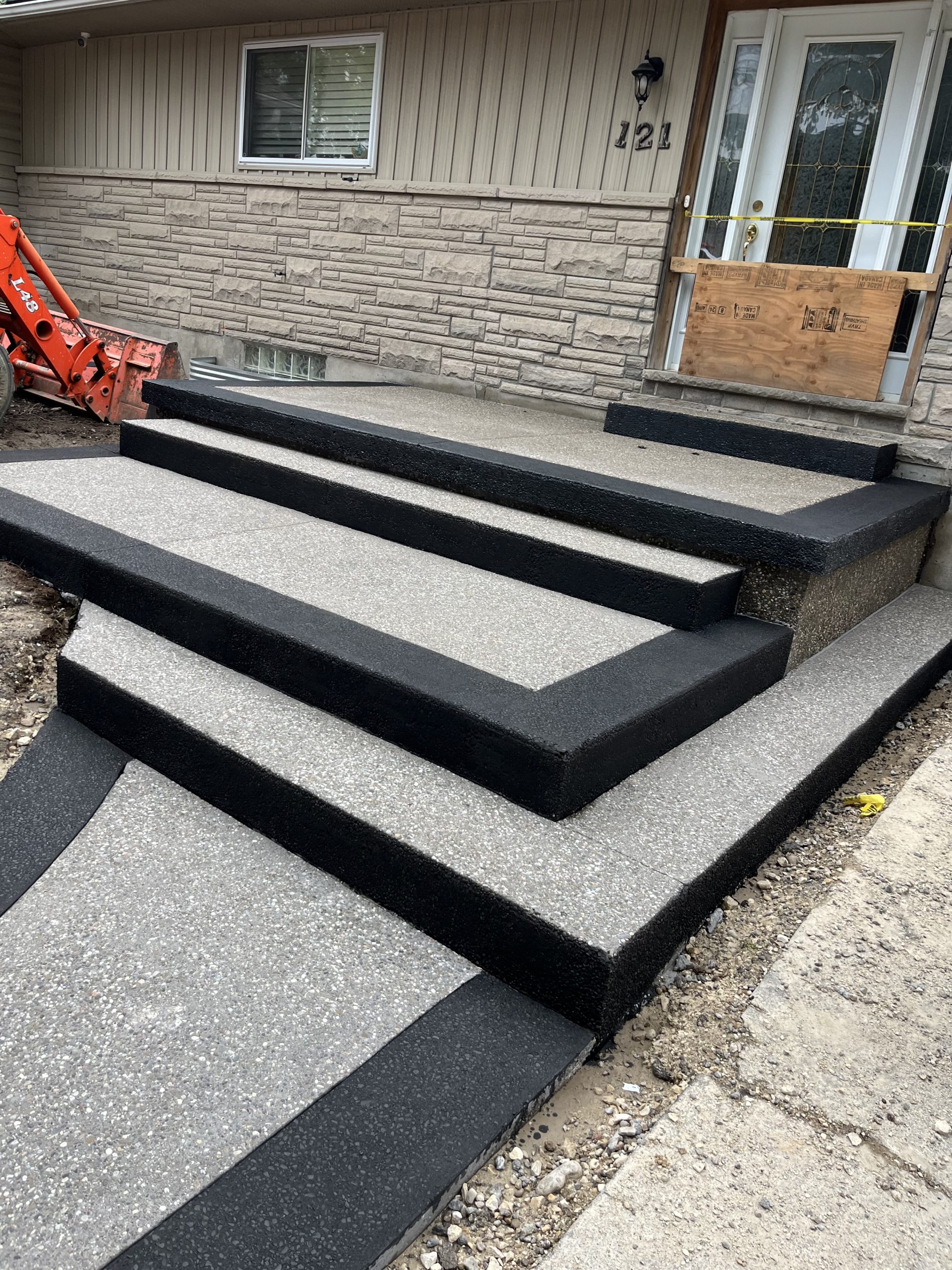BK Concrete Inc. finished exposed aggregate steps with black border in Guelph residential entryway